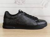 the black sneakers are on a wooden table with a white wall in the background