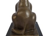 bronze sculpture of a cat sitting on a black marble base