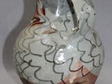 a white and brown vase sitting on a table