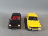 two toy cars sitting next to each other on a table