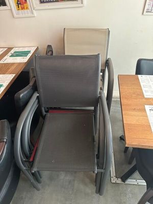 de nombreuses chaises et tables dans une pièce où sont accrochés des tableaux aux murs