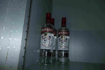 two bottles of vodka sitting on a shelf in a room