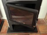 a small stove with a glass door in the corner