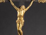a gold statue of jesus on the cross on a black background