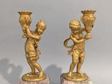 pair of antique bronze figurines of a boy and a girl on marble bases