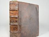 an old book with a few books sitting on top of it