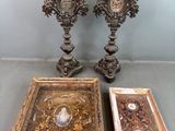 deux vases en argent richement décorés posés à côté d'une photo encadrée sur une table