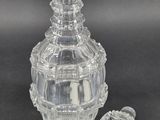 a clear glass bottle with a stopper next to it