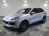 Une Porsche Cayenne argentée est garée sur un sol à damier