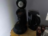 a black coffee maker and a black toaster on a wooden table