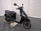 un scooter posé sur sa béquille dans une pièce