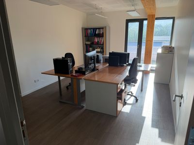un bureau avec deux ordinateurs et une chaise dans la chambre