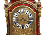 une horloge dorée et rouge, avec des chiffres romains