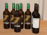 six bouteilles de vin sont alignées sur une table en bois