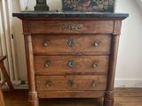 a small chest of drawers with a lamp on top of it