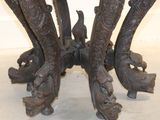 an image of a table with carved legs and a bird on top