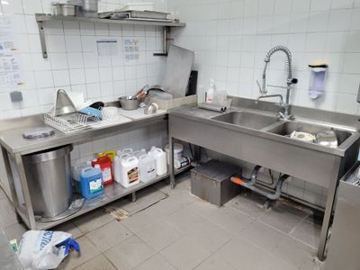 une cuisine équipée d'un évier et d'un plan de travail avec un robinet