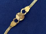 a close up of a gold bracelet on a blue surface
