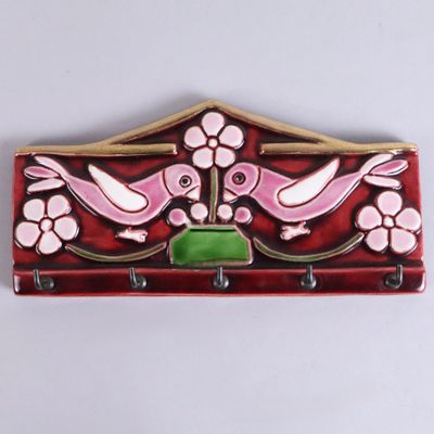 a picture of a red and pink coat rack with two birds on it