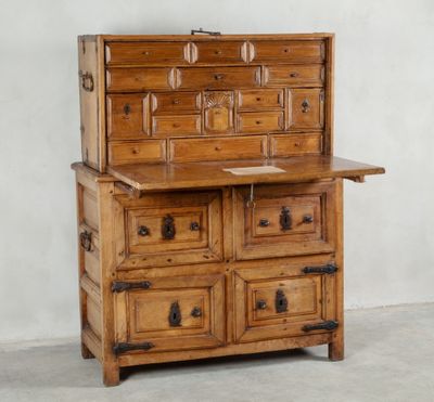 une vieille commode en bois avec de nombreux tiroirs, surmontée d'autres tiroirs