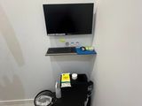 a computer on a stand in the corner of a room