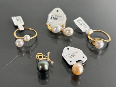 three pairs of pearl and gold rings with price tags on them