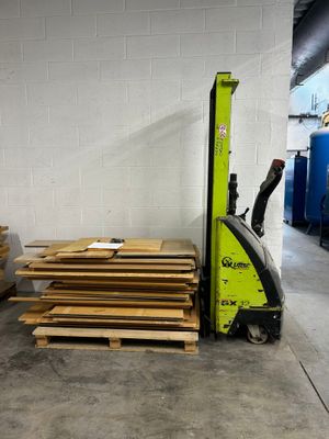 a forklift with pallets of wood in a warehouse