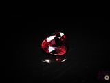 a close up of a red diamond on a black surface