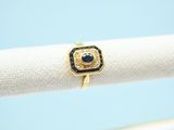 a close up of a gold ring with a black stone on it