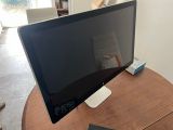 a computer monitor sitting on top of a wooden table