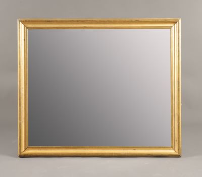 un miroir à cadre doré sur fond gris