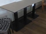 tables and stools in a room with a white tiled wall