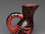 an image of a red and black vase sitting on top of a table
