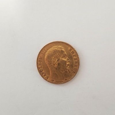 gros plan d'une pièce d'or sur une surface blanche