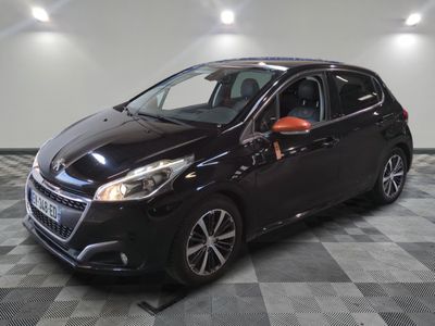 une voiture noire est garée dans une pièce au sol en damier