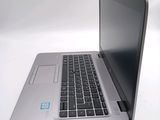 a silver laptop computer sitting on a white surface