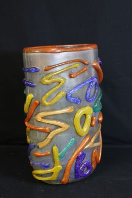 a vase with a colorful design on it on a black background