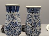 pair of blue and white vases sitting on top of a table