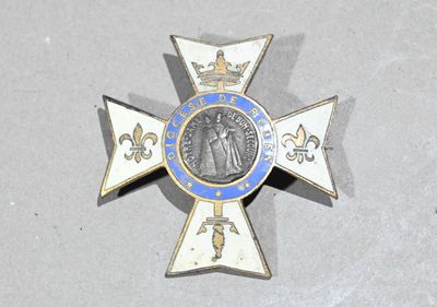 une croix bleue et blanche sur laquelle est accrochée une médaille