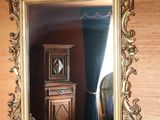 a mirror that is on the wall next to a vase