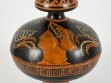 a black and orange vase with a woman on it