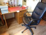 une chaise de bureau noire placée devant un bureau sur lequel sont posés des livres