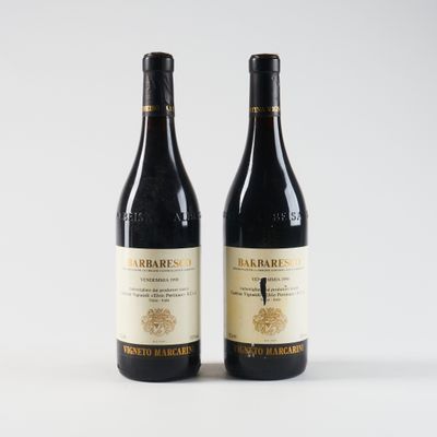 deux bouteilles de vin posées l'une à côté de l'autre sur une surface blanche