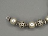 un gros plan d'un bracelet en argent orné de perles