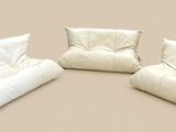 trois poufs blancs empilés les uns sur les autres sur une surface beige