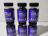 four bottles of good sleep gummies sit on a table