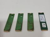 three pieces of green circuit board sitting on top of a white table