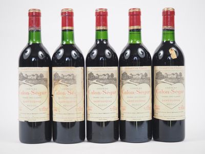quatre bouteilles de vin sont alignées sur une surface blanche