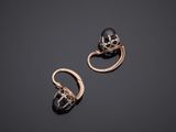 a pair of gold earrings with black pearls and diamonds