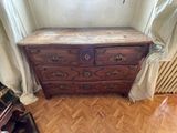 a wooden dresser with a marble top in the corner of a room